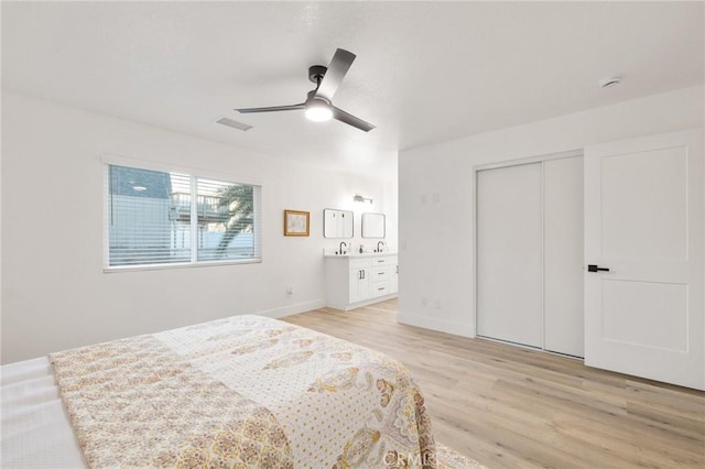 bedroom with a closet, visible vents, ceiling fan, light wood-type flooring, and baseboards