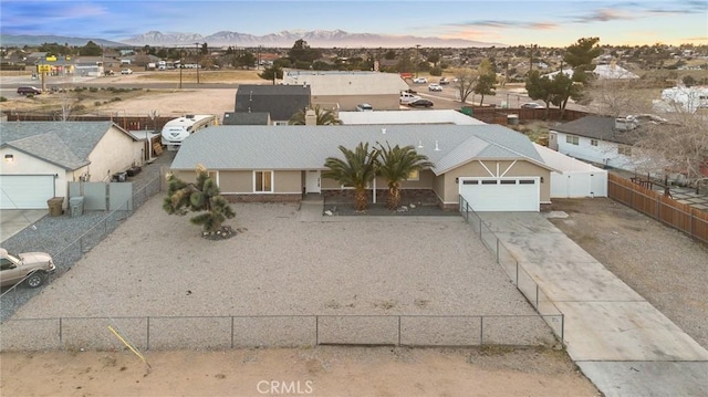 view of front facade featuring driveway, fence, and a mountain view