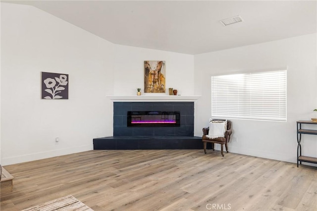 sitting room featuring baseboards, a fireplace, visible vents, and wood finished floors