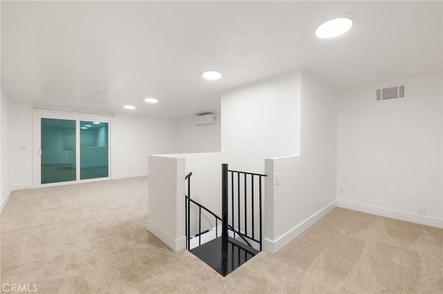 corridor featuring baseboards, visible vents, carpet flooring, and an upstairs landing