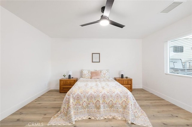 bedroom with light wood-type flooring, visible vents, and baseboards