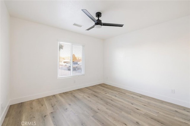 unfurnished room featuring light wood-style floors, baseboards, visible vents, and ceiling fan