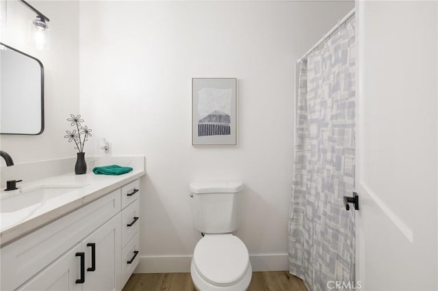 full bathroom with baseboards, vanity, toilet, and wood finished floors