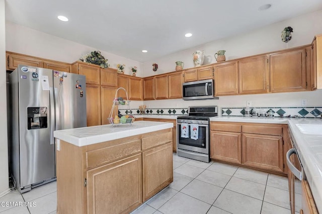 kitchen with decorative backsplash, a center island, light tile patterned floors, and appliances with stainless steel finishes