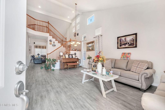 living room featuring hardwood / wood-style flooring, beamed ceiling, high vaulted ceiling, and a chandelier