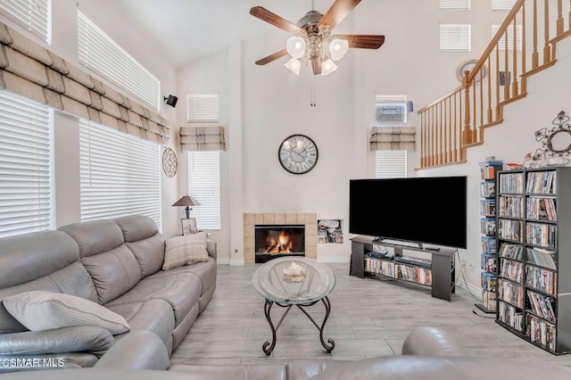 living room with a fireplace, high vaulted ceiling, and light hardwood / wood-style flooring