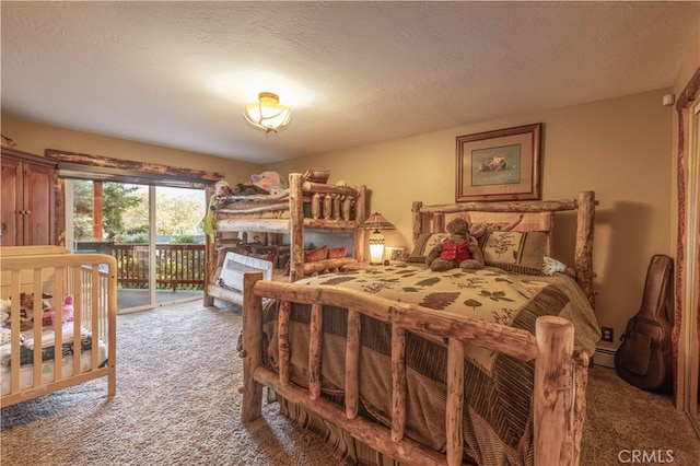 bedroom featuring a textured ceiling, carpet floors, and access to exterior