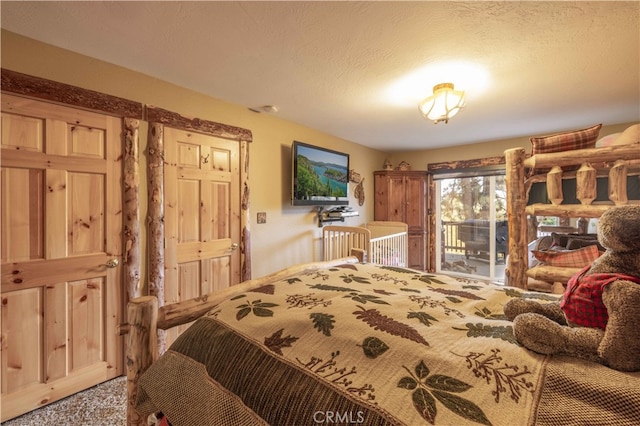 carpeted bedroom featuring a textured ceiling and access to exterior