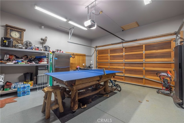 garage with a garage door opener and stainless steel fridge