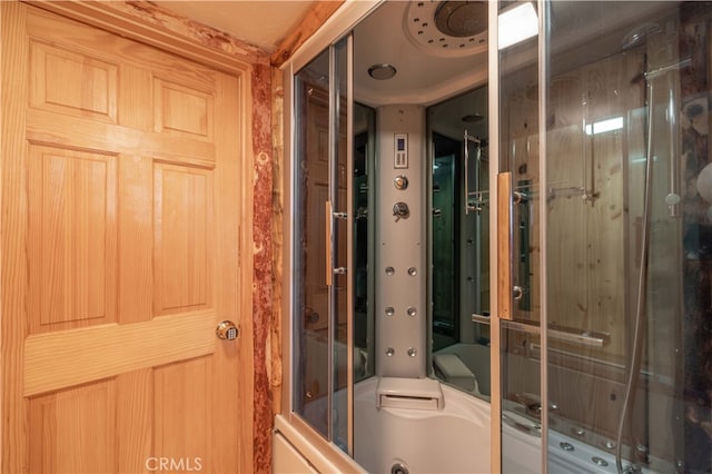 bathroom with bath / shower combo with glass door