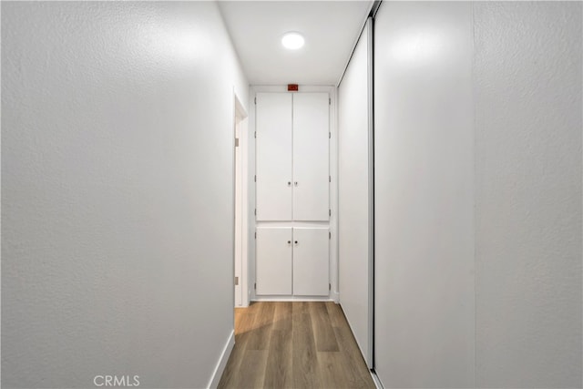 corridor with light hardwood / wood-style flooring