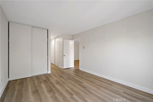 unfurnished bedroom with a closet and hardwood / wood-style flooring