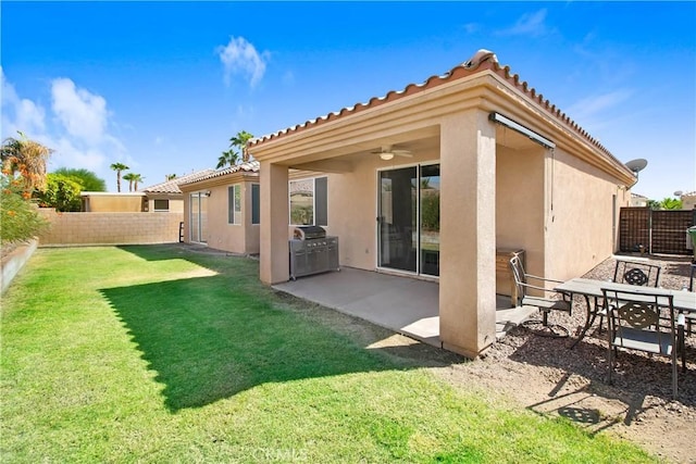 back of property featuring ceiling fan, a patio area, and a lawn