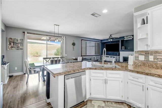 kitchen with white cabinets, sink, stainless steel dishwasher, ceiling fan, and kitchen peninsula