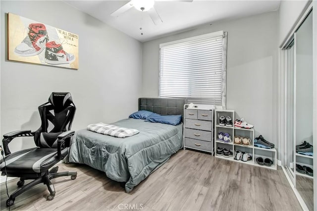 bedroom featuring ceiling fan, a closet, and light wood-type flooring