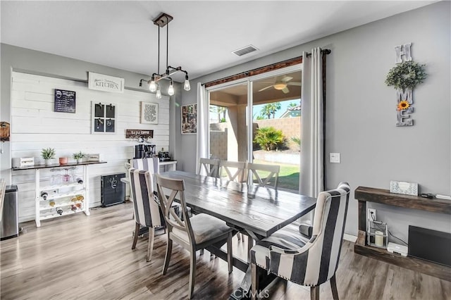 dining space featuring wood walls and light hardwood / wood-style floors