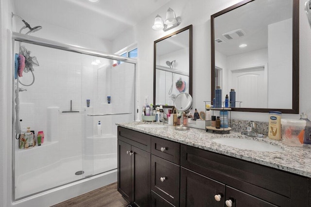 bathroom featuring vanity, hardwood / wood-style floors, and a shower with door