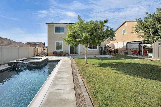 rear view of property featuring a swimming pool with hot tub, a gazebo, a lawn, and a patio