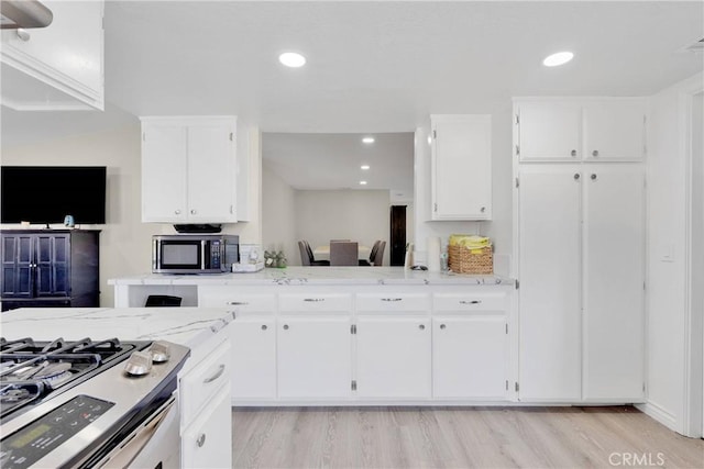 kitchen featuring white cabinets, stainless steel appliances, and light hardwood / wood-style floors