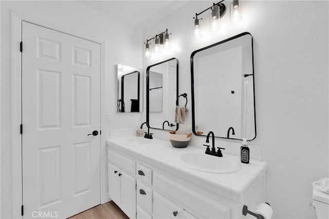 bathroom featuring wood-type flooring, vanity, and toilet