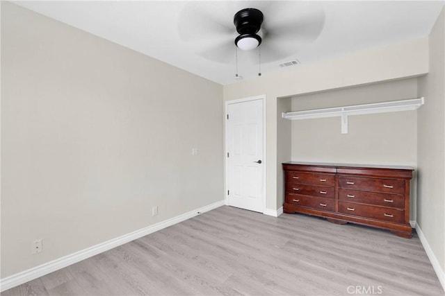 unfurnished bedroom featuring ceiling fan, light hardwood / wood-style floors, and a closet