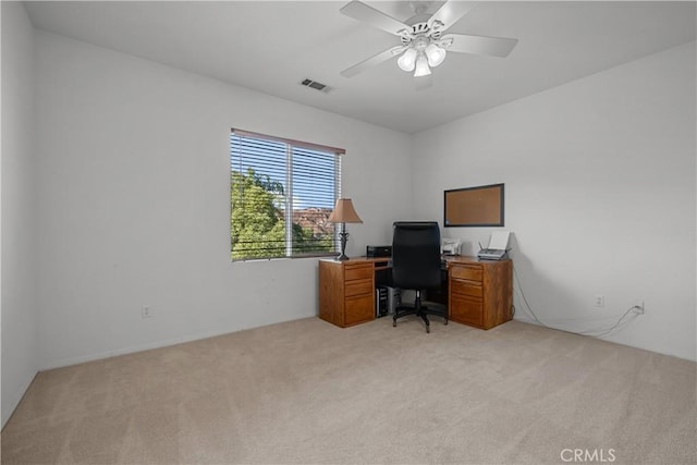 carpeted home office featuring ceiling fan