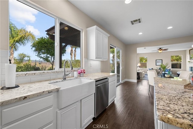 kitchen featuring stainless steel dishwasher, light stone counters, ceiling fan, dark wood-type flooring, and white cabinets