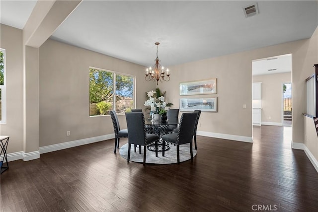 dining space featuring dark hardwood / wood-style floors and an inviting chandelier