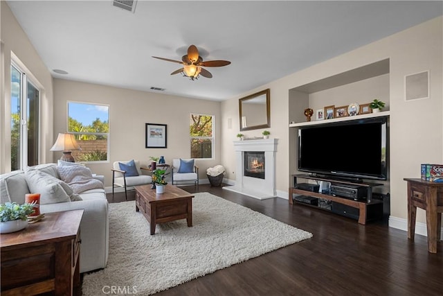 living room with dark hardwood / wood-style flooring and ceiling fan