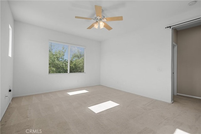 unfurnished room with ceiling fan and light carpet