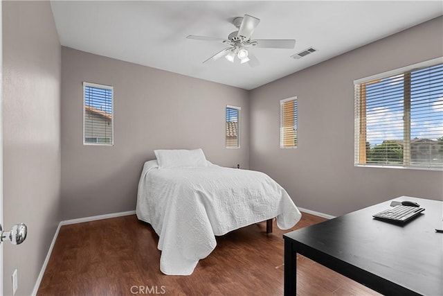 bedroom featuring ceiling fan, dark hardwood / wood-style flooring, and multiple windows