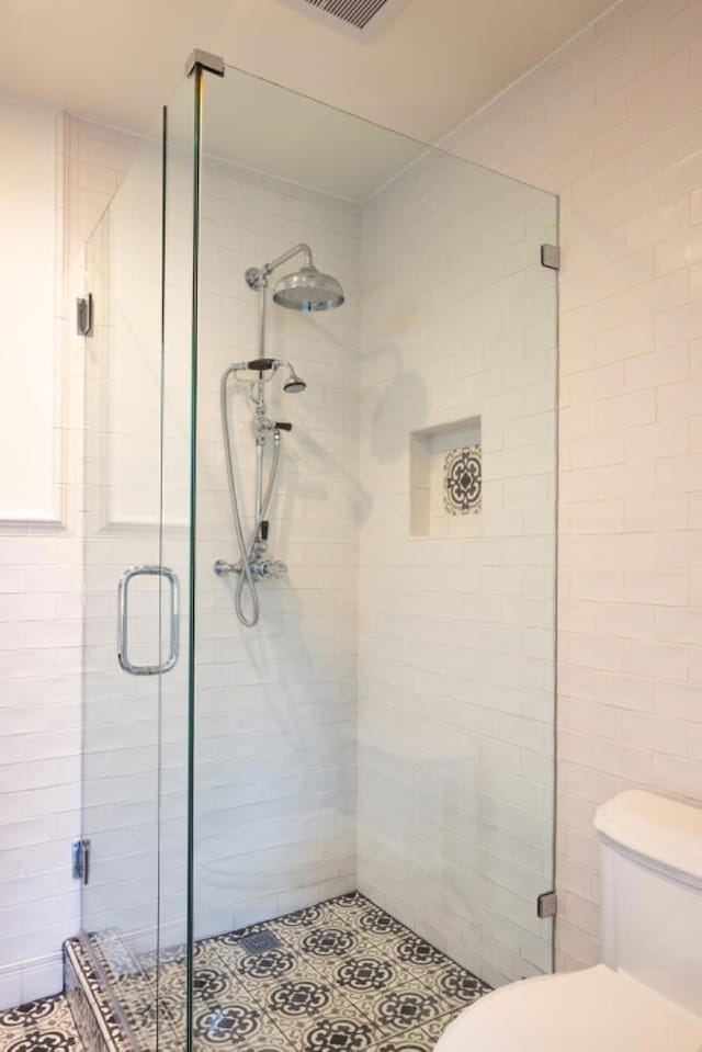 bathroom featuring an enclosed shower and toilet