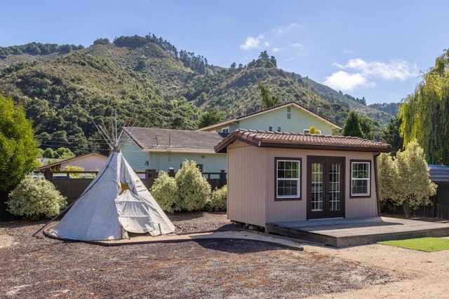 rear view of property with an outdoor structure and a mountain view