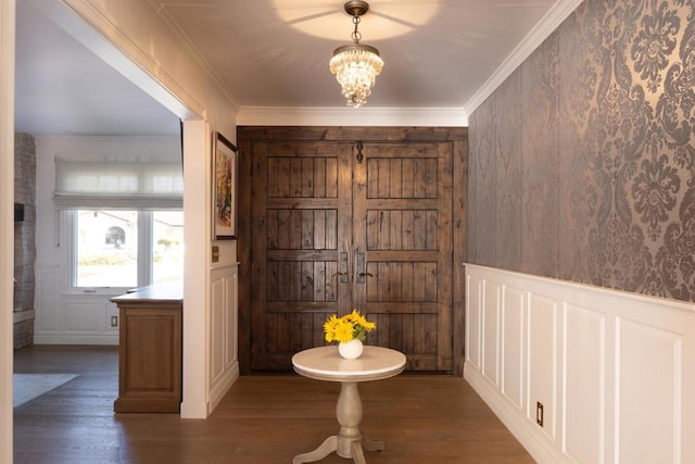 foyer with an inviting chandelier, crown molding, and dark hardwood / wood-style floors