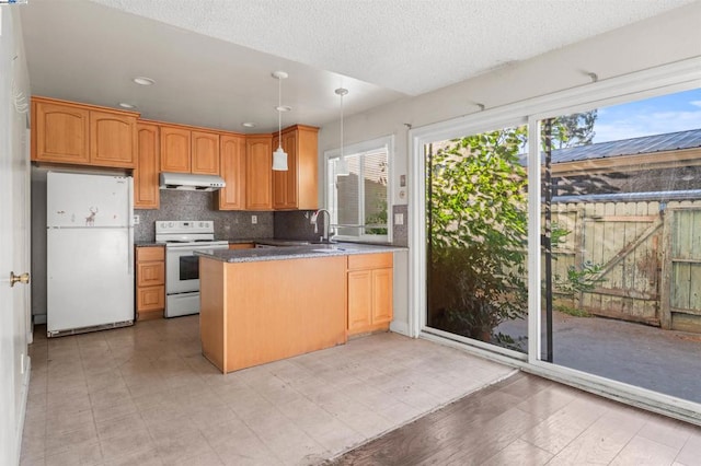 kitchen with decorative backsplash, white appliances, kitchen peninsula, pendant lighting, and a textured ceiling