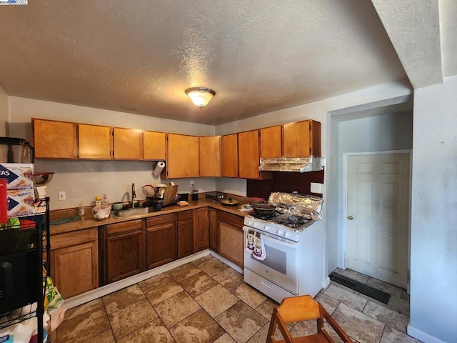 kitchen with a textured ceiling, sink, white range with gas cooktop, and ventilation hood