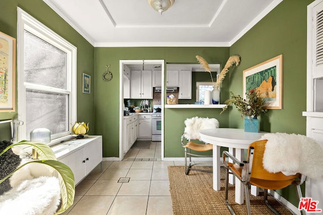 interior space with light tile patterned flooring, ornamental molding, extractor fan, white cabinetry, and white range