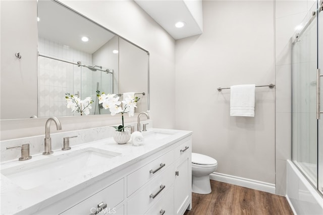 bathroom with toilet, hardwood / wood-style floors, and vanity