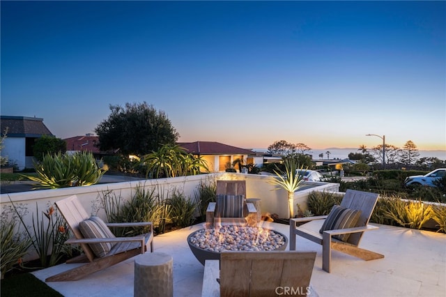 patio terrace at dusk featuring an outdoor fire pit