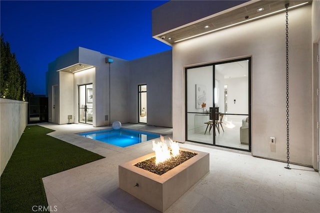 pool at twilight with a patio, a hot tub, and an outdoor fire pit