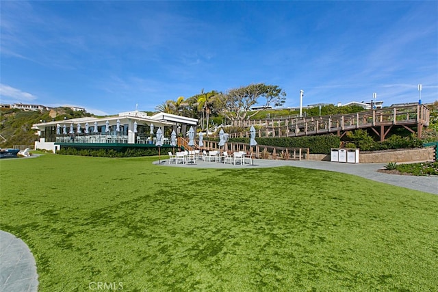 view of home's community with a lawn and a patio area