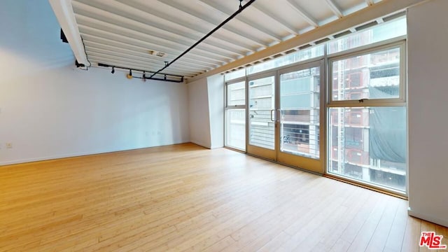 unfurnished room featuring a healthy amount of sunlight and hardwood / wood-style floors