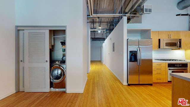 kitchen featuring washer / clothes dryer, light brown cabinets, stainless steel appliances, and light hardwood / wood-style floors