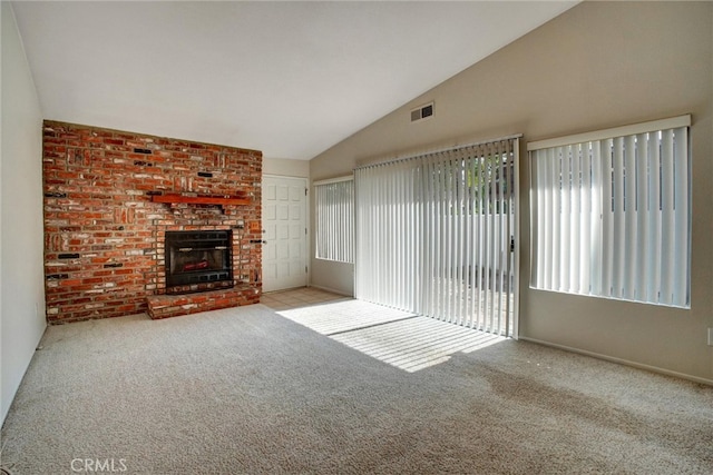 unfurnished living room featuring light carpet, a fireplace, and vaulted ceiling