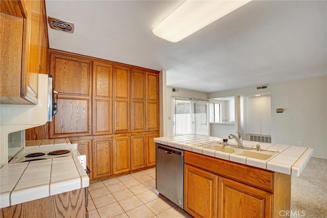 kitchen with tile counters, dishwasher, and a kitchen island