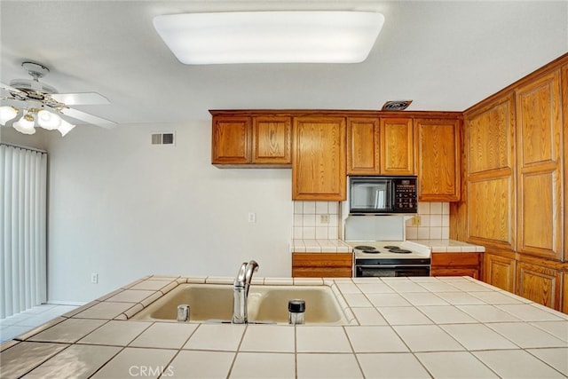 kitchen with sink, ceiling fan, white range with electric stovetop, tile counters, and decorative backsplash