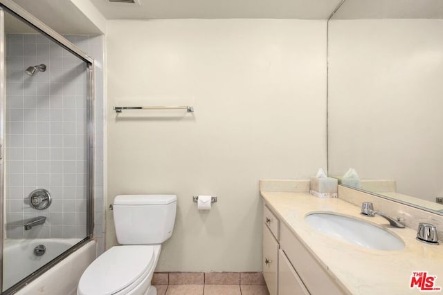 full bathroom featuring tile patterned flooring, vanity, toilet, and combined bath / shower with glass door