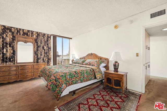 carpeted bedroom featuring a textured ceiling