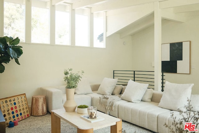 carpeted living room featuring lofted ceiling with beams and a wealth of natural light