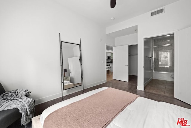 bedroom with ensuite bathroom, ceiling fan, and dark wood-type flooring